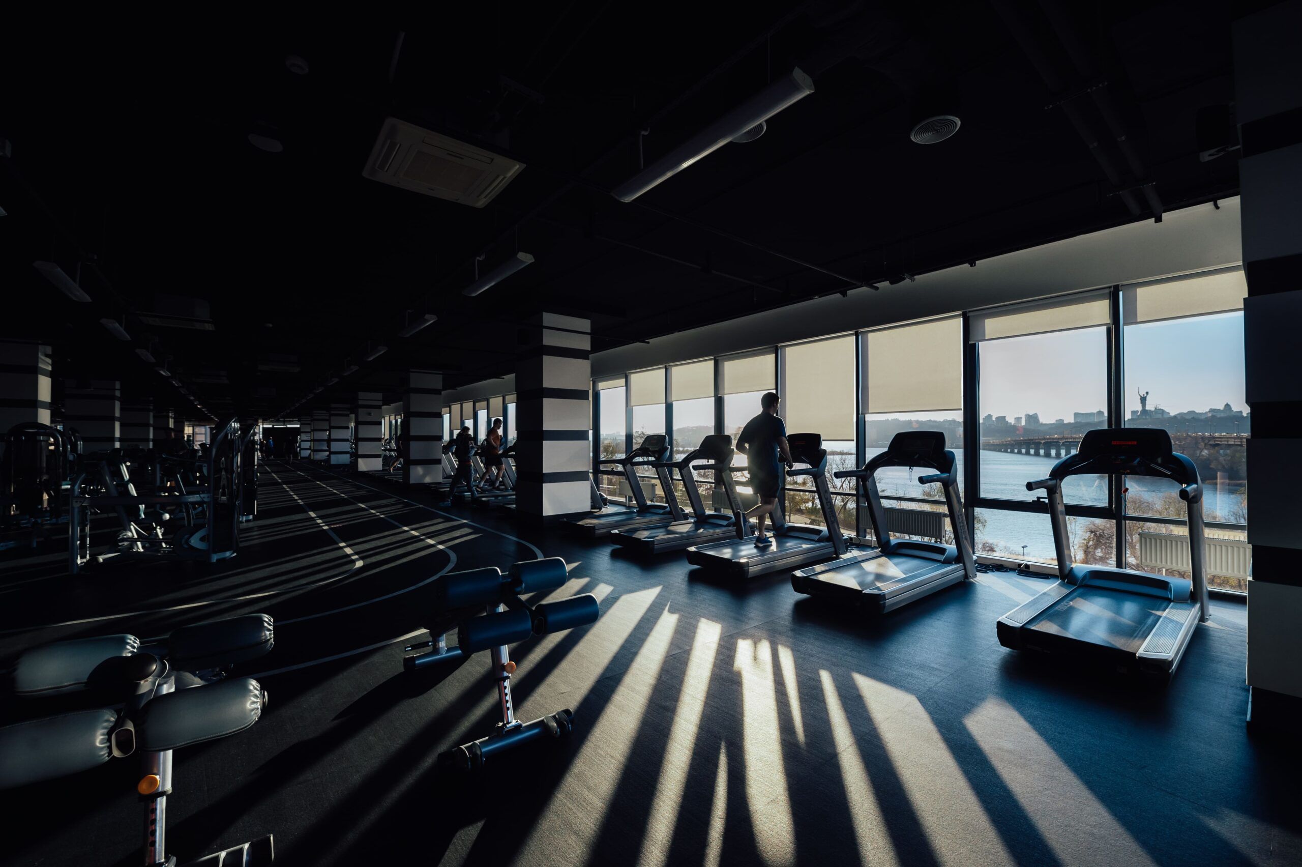 Person performing controlled mobility and functional exercises inside a fitness center